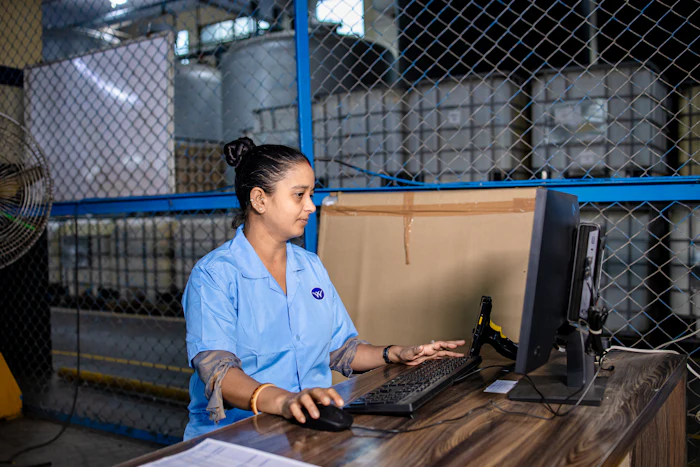 Trabajadora revisando información en una computadora dentro de un almacén