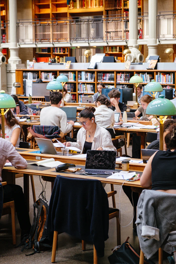 Estudiantes trabajando con sus computadoras en una sala de lectura