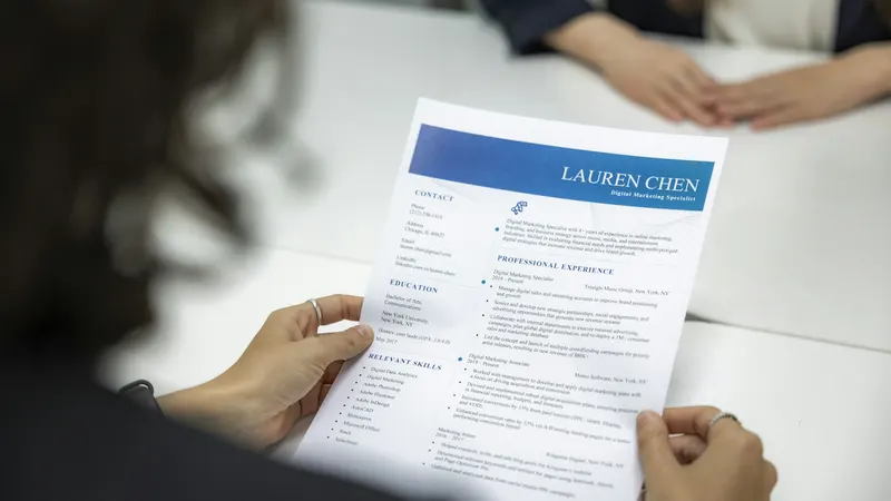 Mujer revisando un currículum sobre una mesa
